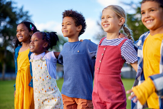 Happy multiethnic children friends jumping in a row