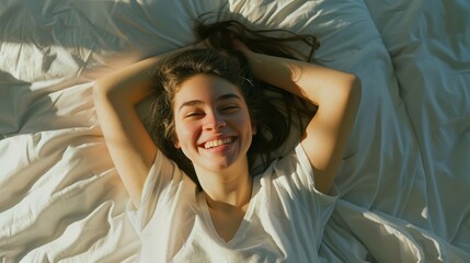 Fototapeta premium A joyful young woman with flowing hair lies on her bed, smiling brightly as the morning light filters through the window.