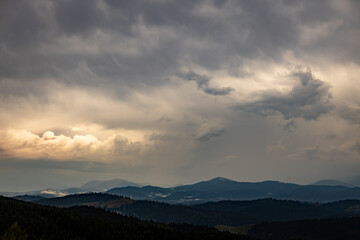 Sunrise in the mountains, panoramic view, mountain peaks with clouds.