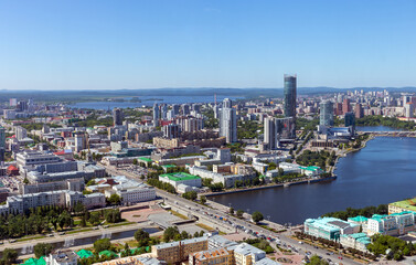 Obraz premium Above view of central part of modern city with skyscrapers and residential buildings. River and bridge on summer day