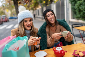 Diverse friends enjoying tea after shopping winter outdoor cafe lifestyle multicultural women friendship