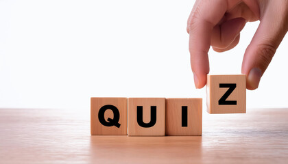 Naklejka premium A hand is holding a block of wood with the letters Q, U, I, Z on it