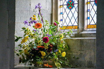 Beautiful flowers in church window with stained glass