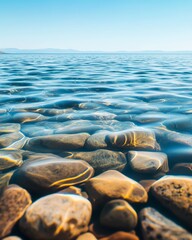 Clear turquoise water with visible rocks on the bottom of a calm sea.