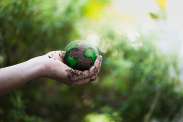 The soil in the human hand resembles a globe. Environmental concept on Earth Day