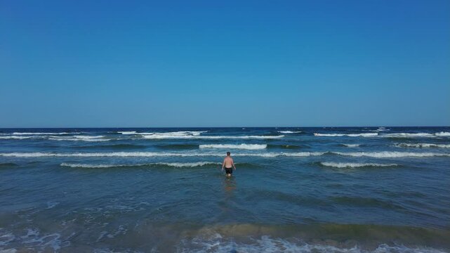 Mann taucht in die Wellen der Ostsee