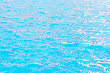 Azure blue water surface with reflections of light from the sun. Abstract background
