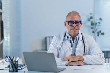 the doctor work with laptop at table in clinic. Online consultation