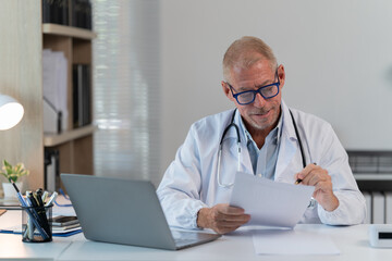 the doctor work with laptop at table in clinic. Online consultation