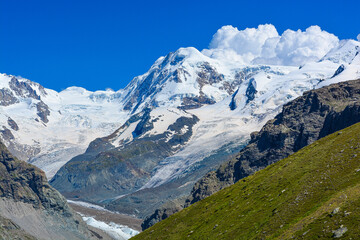 Swiss Alps peaks and ridges covered in snow in Summer. Stunning mountain landscape in Switzerland. Panoramic shot. Space for copy. 