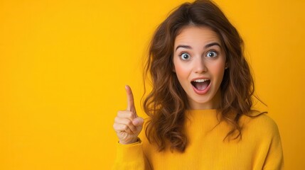 Woman with surprised expression pointing up, yellow background.