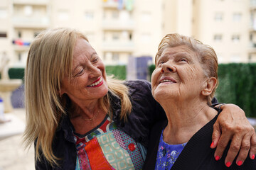 Mother and daughter laughing and having fun on the terrace