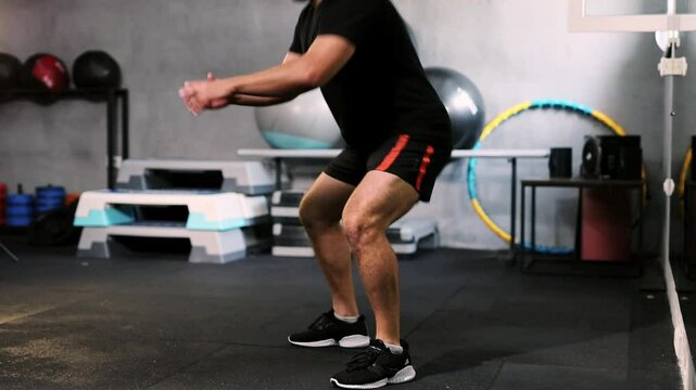 Fit young guy doing strength exercises in GYM
