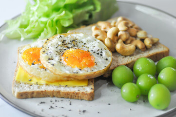 toast or bread with sunny side up egg , cashew nut , grape and lettuce