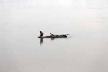 Workers dig sand from a river and load it onto trucks in Cameroon