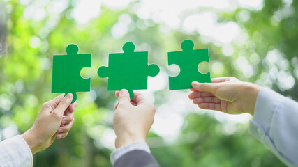 Business leaders collaborate on green partnership, fitting together the pieces of environmental,...