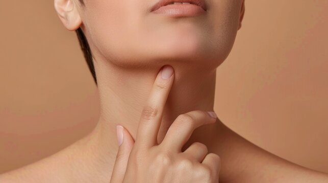 close up of woman pointing to lower jaw and neck
