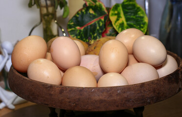 Eggs in a wooden bowl on a table in the kitchen