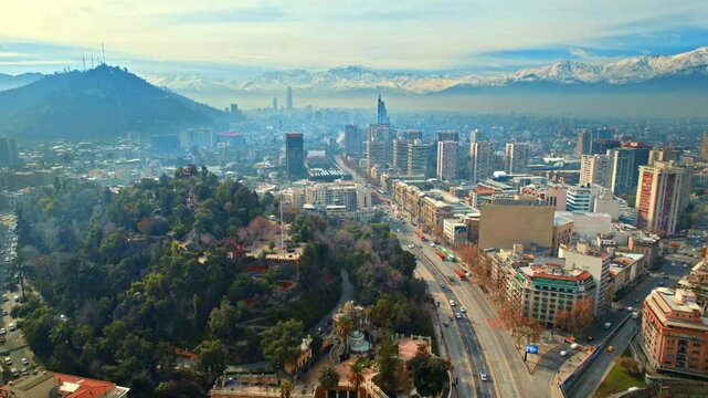 Establishing Aerial of Santiago de Chile Santa Lucia Hill, Alameda Avenue city and andean cordillera mountain background, slow panoramic