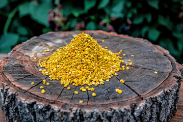 Heap of healthy bee pollen on wooden stump