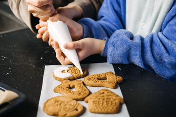 Mother and daughter decorating Christmas cookies together, holiday baking tradition, festive kitchen, family bonding, Christmas countdown, creating holiday magic.