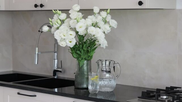 woman in kitchen drinking water with lemon,pouring in glass, holding cup of coffee, eating waffles with berries.flowers in vase on counter.girl eating breakfast in the morning.