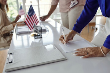Close-up of people filling documents and voting at election day
