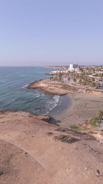 Tranquil vertical aerial panorama of Playa Flamenca and Cala Mosca beach, highlighting the unique coastline and sandy beach against the backdrop of Orihuela Costa, Spain.