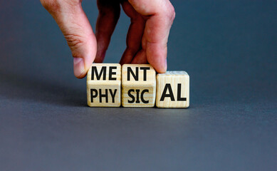 Mental or physical symbol. Concept word Mental or Physical on wooden cubes. Beautiful grey table grey background. Doctor hand. Business lifestyle and mental or physical concept. Copy space.