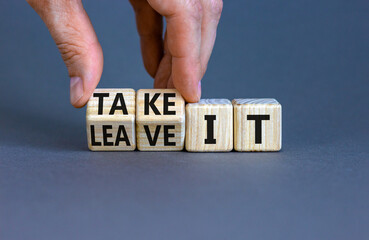 Take or leave it symbol. Businessman turns beautiful wooden cubes and changes words Leave it to Take it. Beautiful grey table grey background. Copy space. Business and take or leave it concept.