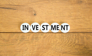Investment symbol. Concept word Investment on beautiful white pill. Beautiful wooden background....