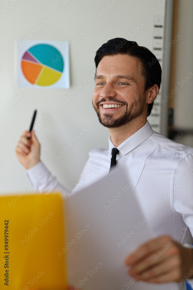 Aufkleber a man is smiling and holding a pen in front of a whiteboard with a pie chart on it