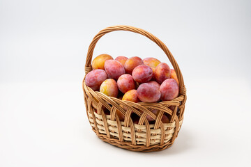 Beautiful ripe sweet plums in a basket isolated on white background. Close up.