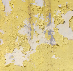 Cracked yellow paint on the wall as an abstract background. Texture