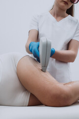 Naklejka premium Body laser hair removal in a modern cosmetic salon. The specialist uses advanced techniques for effective hair removal and client comfort.