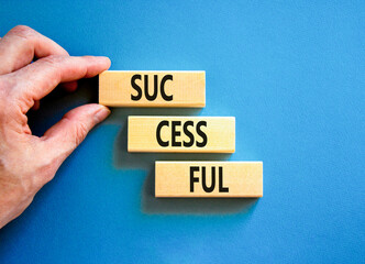 Successful symbol. Concept word Successful on beautiful wooden blocks. Businessman hand. Beautiful blue background. Business successful concept. Copy space.