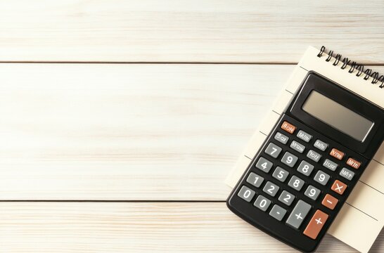 Calculator and Notebook on White Wooden Table