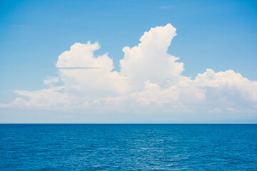 Blue sky with fluffy cloud in sea background