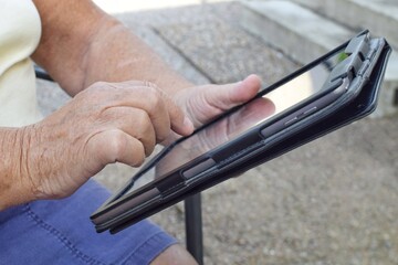 Elderly women holding a tablet. Finding out news from the Internet or communicating with relatives.