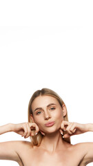 Vertical portrait of attractive young woman with both clear face, doing facial lifting massage with hands isolated on white background. Concept of beauty, plastic surgery, face lifting, face building