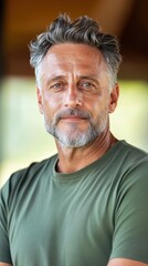 Obraz premium A middle-aged man with a rugged appearance, including visible scars and uneven skin, dressed in casual, comfortable clothing, highlighting natural beauty