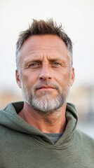 Obraz premium A middle-aged man with a rugged appearance, including visible scars and uneven skin, dressed in casual, comfortable clothing, highlighting natural beauty