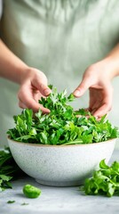 A person preparing a salad with homegrown greens and herbs, with a focus on the hands and ingredients, emphasizing the freshness and sustainability of the meal