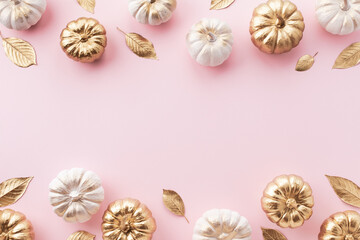 Stylized white and gold decorative pumpkins and golden leaves border on a pale pink background for autumn and Thanksgiving cards.