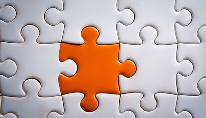 Picture of an orange puzzle piece that fits into a white puzzle. Teamwork, solutions, and problem-solving concepts are emphasized.