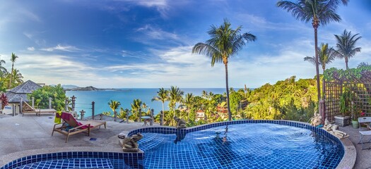 View over an infinity pool on a slope above a tropical beach