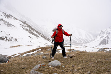 Male mountain climber on top of snowy peak.