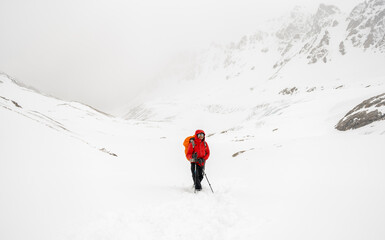 Male mountain climber on top of snowy peak.