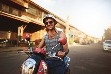 Man, scooter and street travel for holiday vacation or explore Bali with helmet, journey or road trip. Male person, sunglasses and summer tourist on outdoor transportation or weekend, ride or getaway