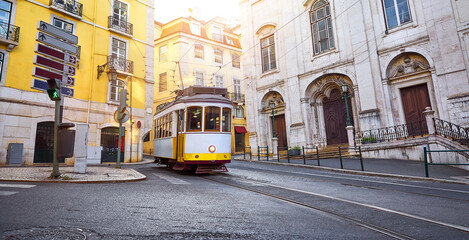 Lisbon, Portugal. Vintage retro tram on narrow bystreet tramline in Alfama district of old town. Popular touristic attraction Lisboa city. Public tramways trasport